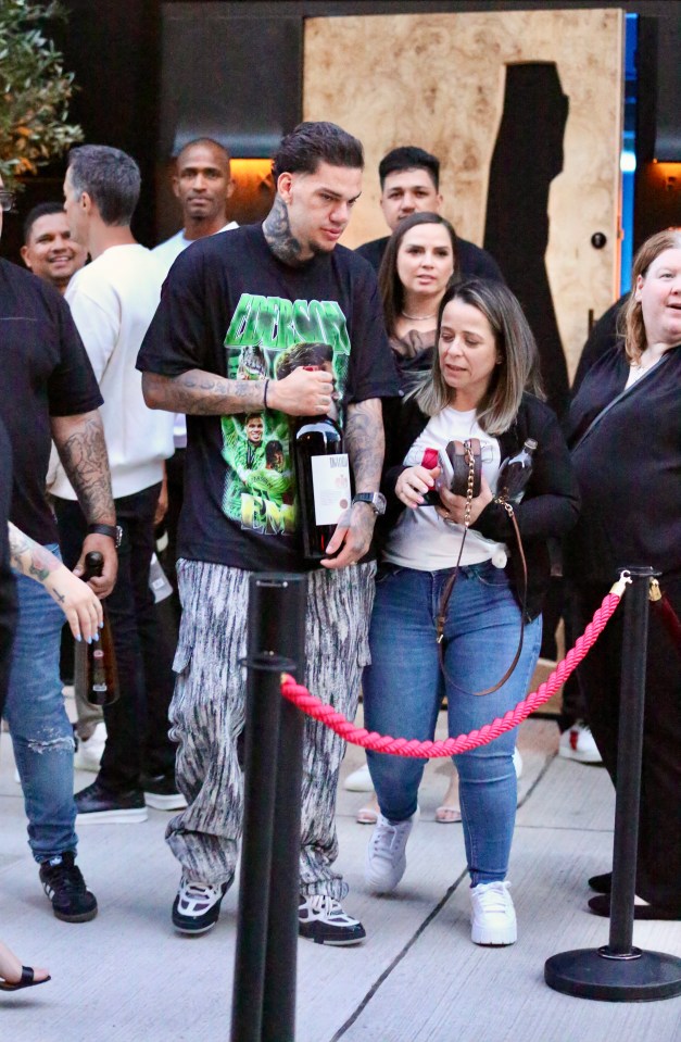 He was later seen holding a £1280 bottle of red wine as he left