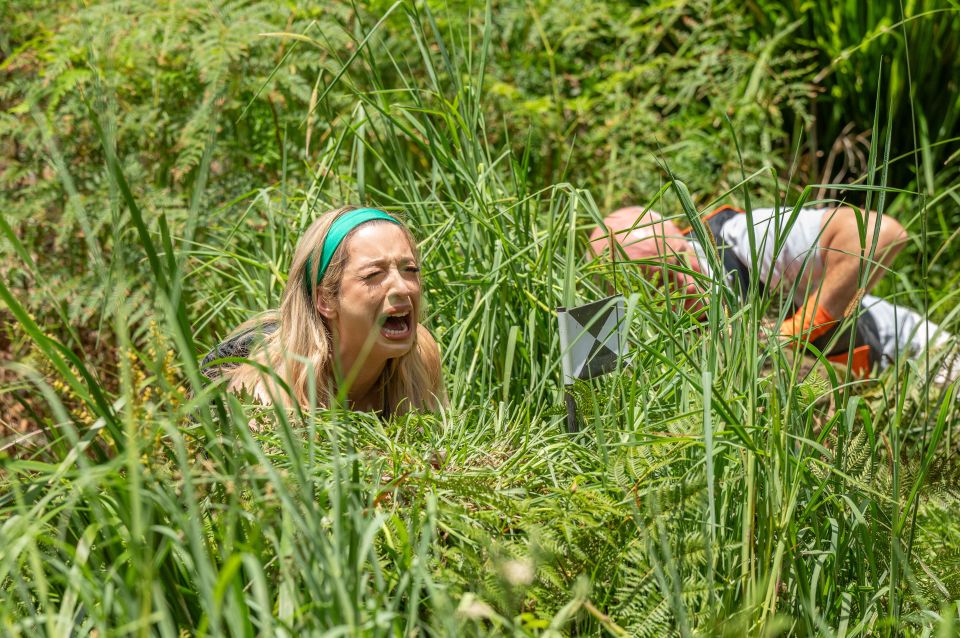 a woman is laying in the grass with her mouth open