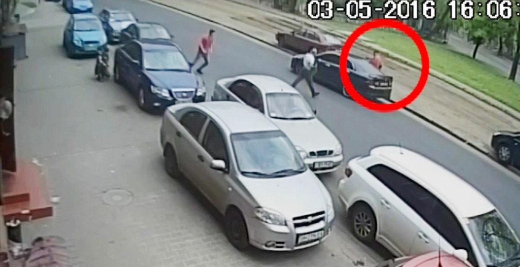 A mass brawl breaks out in the street, with fists flying on both sides, before one of the thugs returns to his car to pick up the weapon