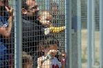 Migrants wait nearby the entrance of Hun