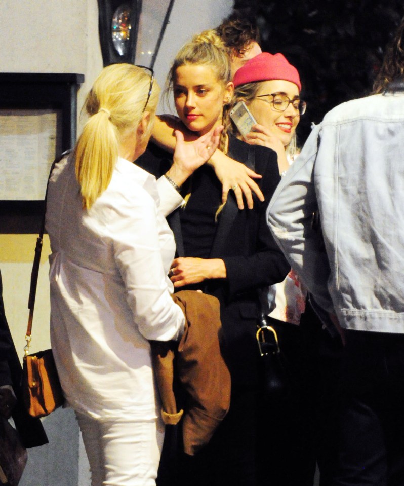 Amber was pictured hugging her pals as she waited in line