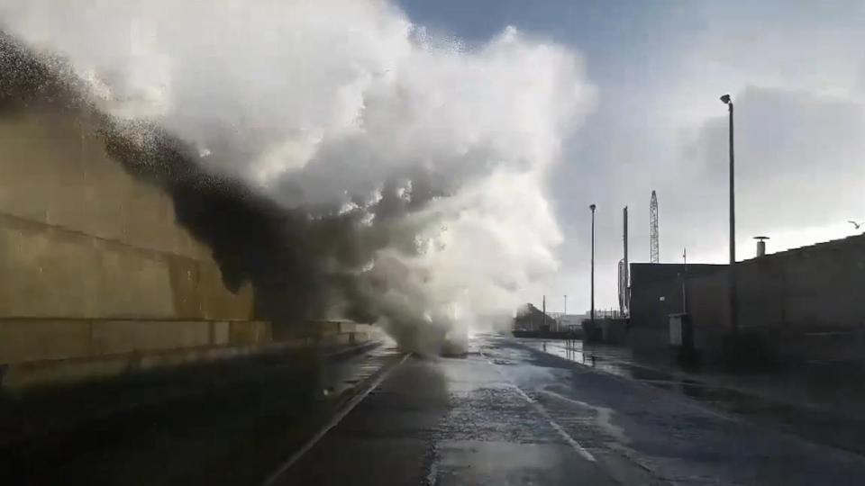 The moment the huge wave crashes over the sea wall