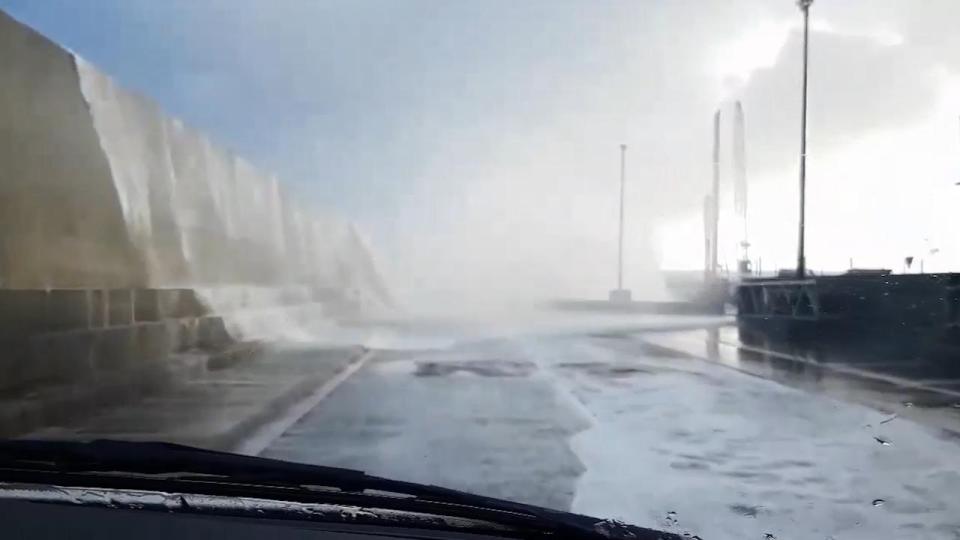 The road was drenched after the water surged over the huge sea wall