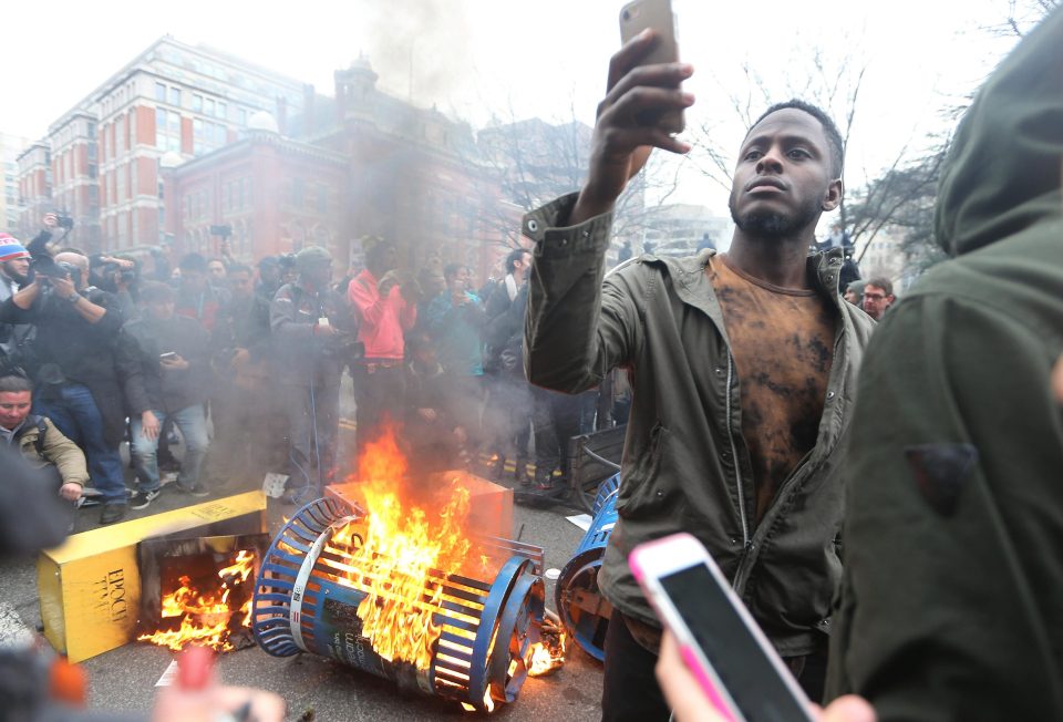 Anti-Trump protesters set bins on fire during clashes in Washington DC today