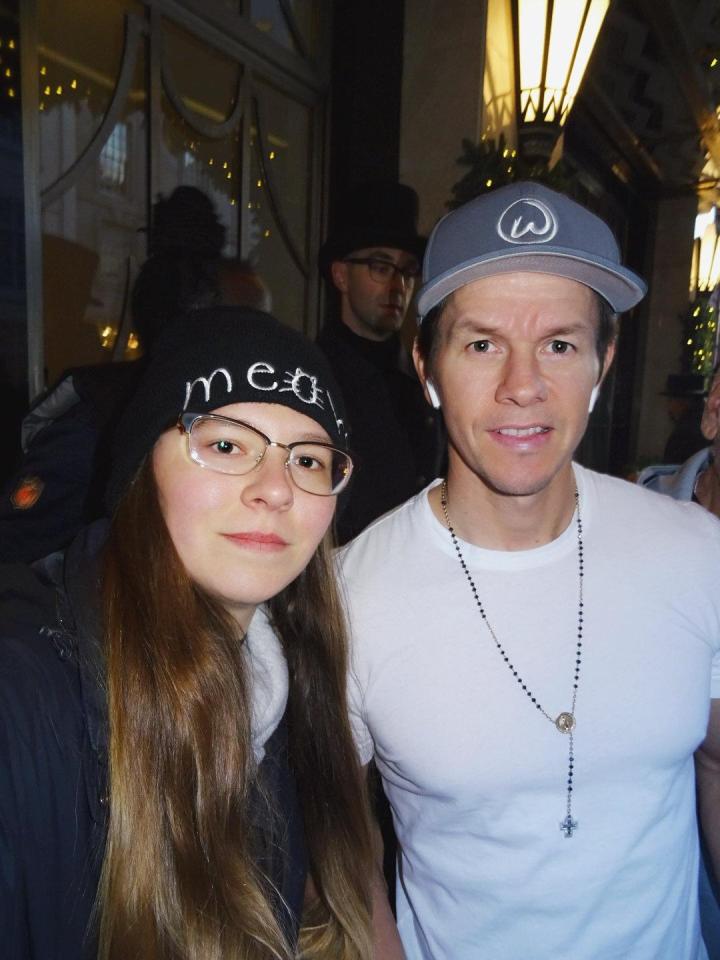 The 25-year-old poses next to actor and producer Mark Wahlberg 