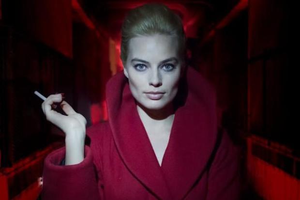 Margot Robbie in a red cloack holding a cigarette in a still from new film Terminal