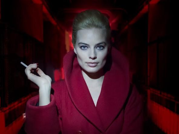 Margot Robbie in a red cloack holding a cigarette in a still from new film Terminal