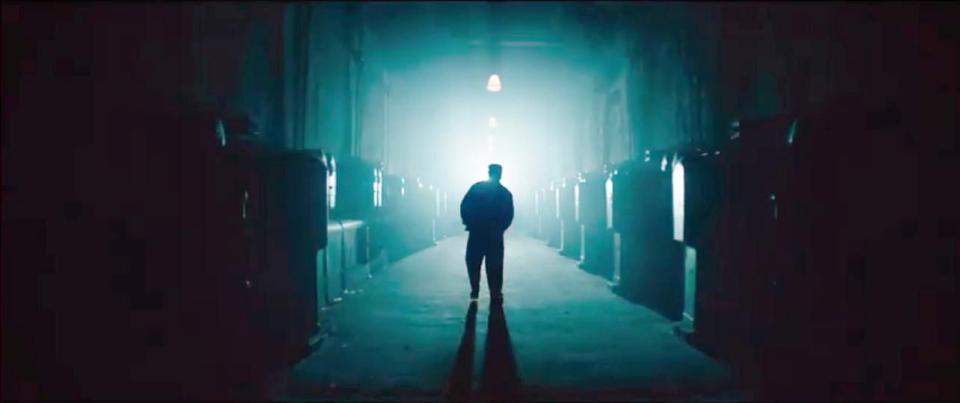A man is silhoutted against a bright light in a city in a scene from noir thriller Terminal 