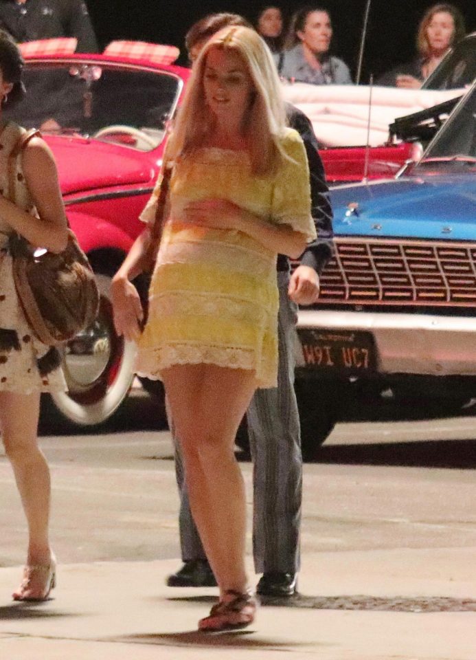 The star was seen cradling her false bump in a bright yellow dress as she filmed new scenes for the 60s thriller, directed by Quentin Tarantino