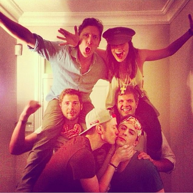  Another shot shows her on the shoulders of a friend as boyfriend Tom kisses another man on the cheek