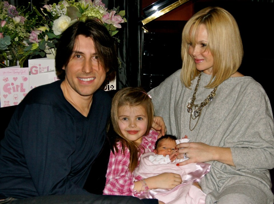 a family posing for a picture in front of a sign that says girl