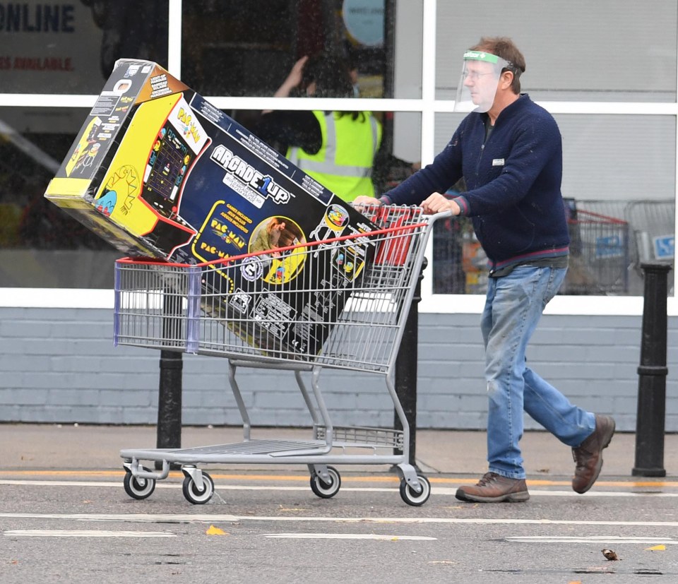 A man is pictured with an arcade machine in his trolley as he gears up for lockdown