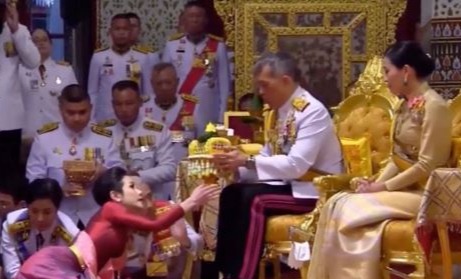 The king used ceremonial water to anoint his long-term girlfriend while she lay at his feet - and those of his queen