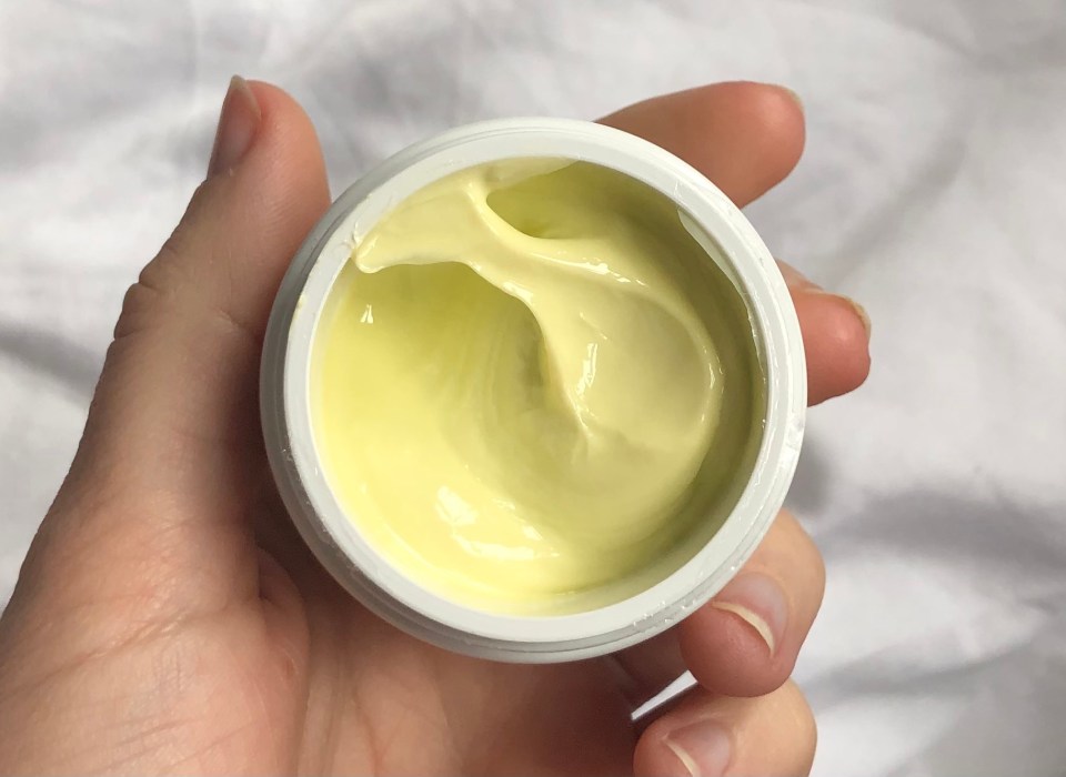 Pale yellow cream in a white jar.