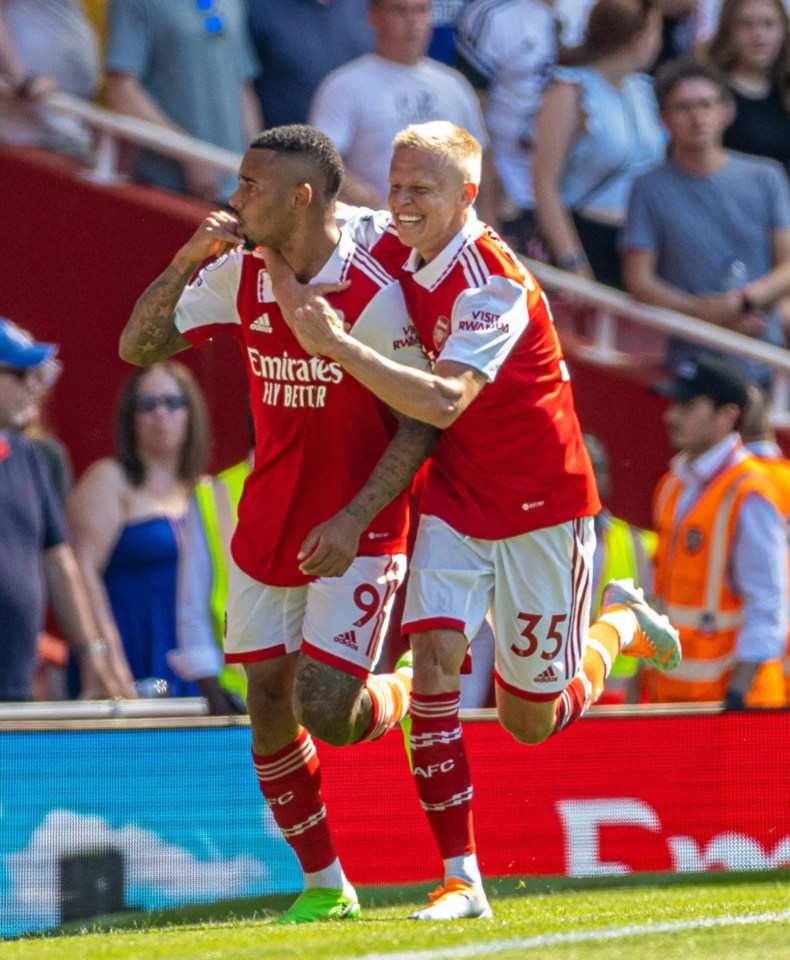 two soccer players wearing emirates fly better jerseys are celebrating