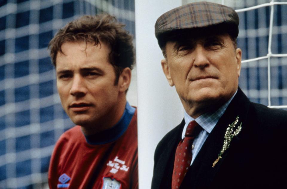 two men standing next to each other one of whom is wearing a shirt that says ' united ' on it