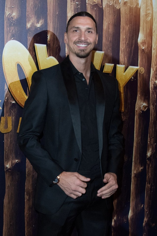 a man in a black suit stands in front of a sign that says ok
