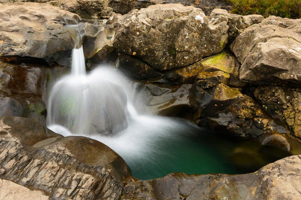 Some people brave their chilly waters of the fairy pools on the river Brittle