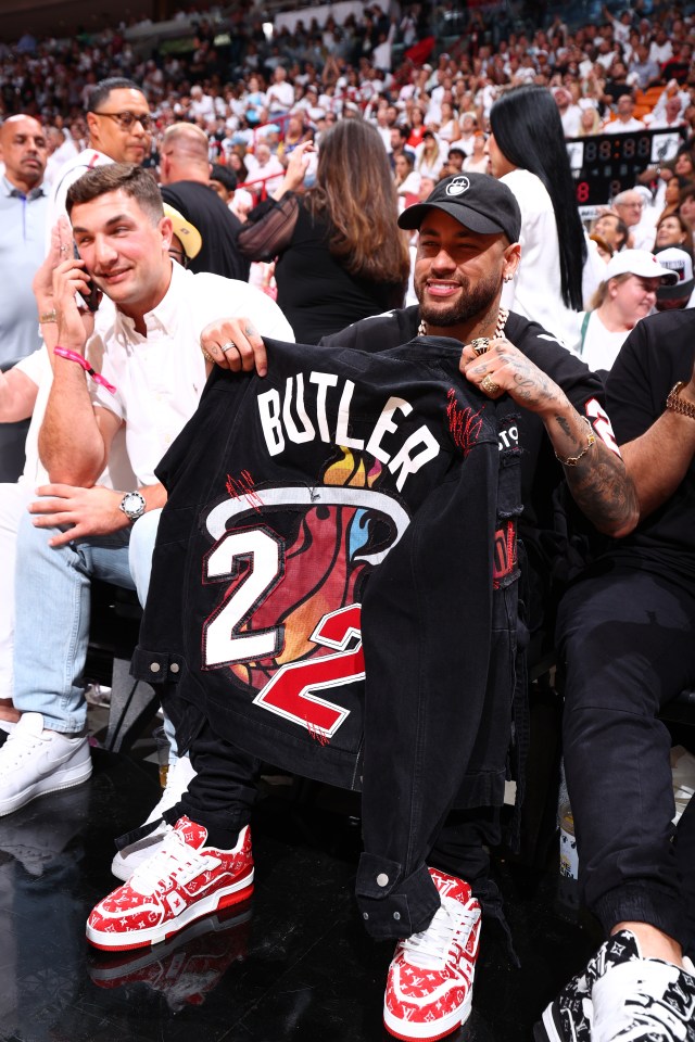 Neymar clutched a Jimmy Butler T-shirt while sat courtside