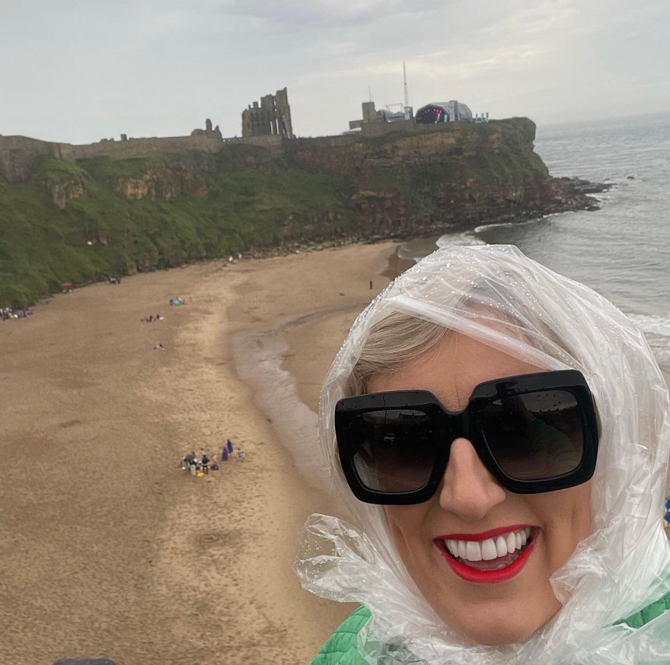 The TV presenter has used a recycled plastic bag to help protect herself from the rain