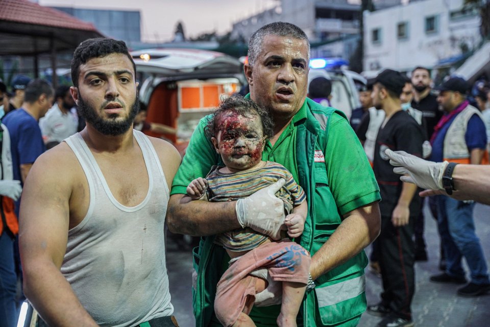 A paramedic holds a girl after bombing in Gaza
