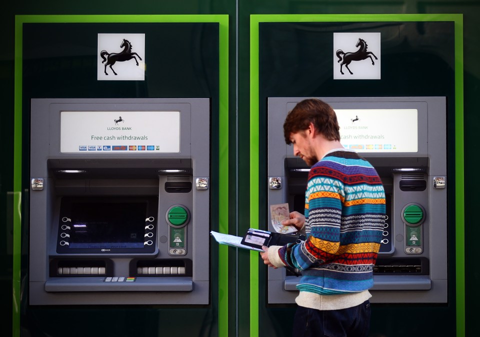 a man using an atm machine that says free cash withdrawals