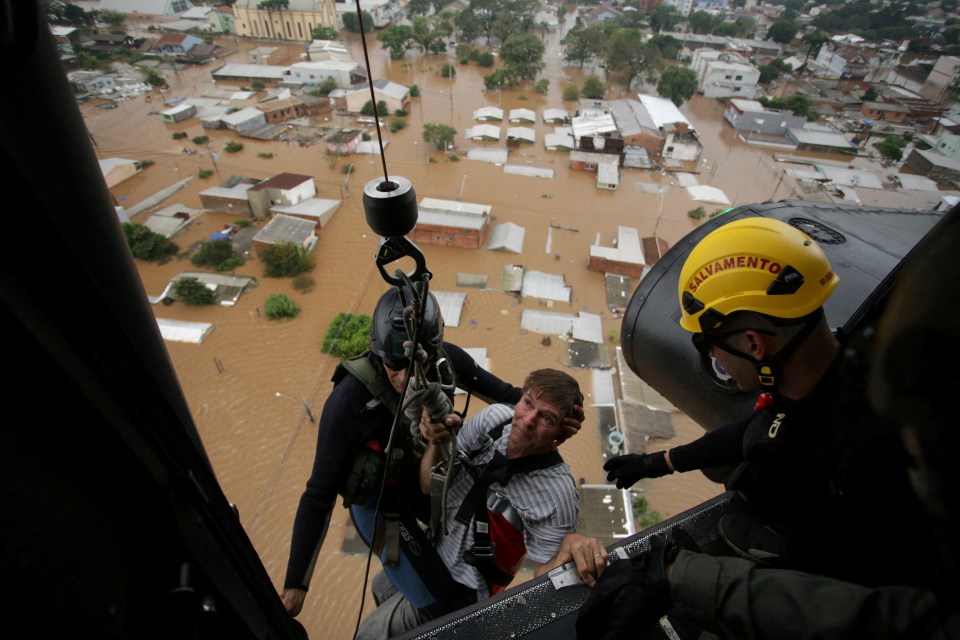 A man  being rescued by military firefighters in Canoas, at the Rio Grande do Sul state