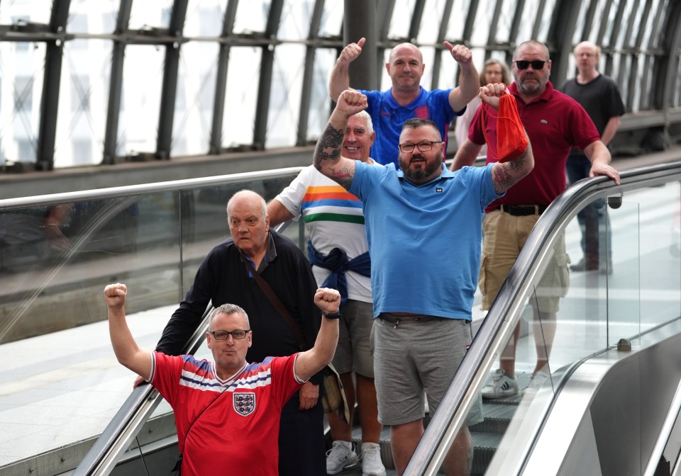a group of men on an escalator with one wearing a shirt that says england