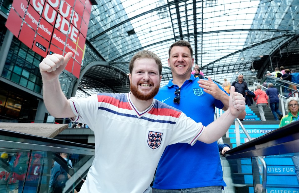 two men giving a thumbs up in front of a sign that says your guide