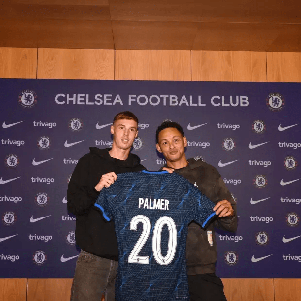a man holding a jersey with the number 20 on it