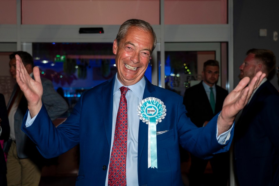 a man in a blue suit and tie has a green badge on his chest