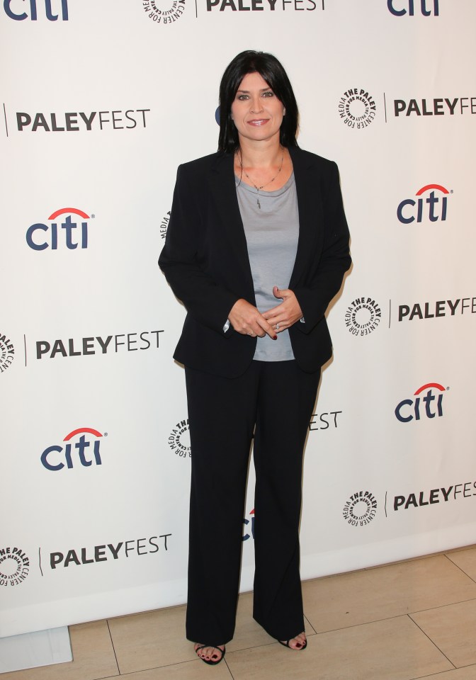 a woman stands in front of a wall that says citi paleyfest