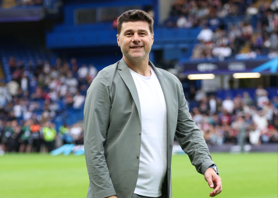a man in a suit is walking on a soccer field