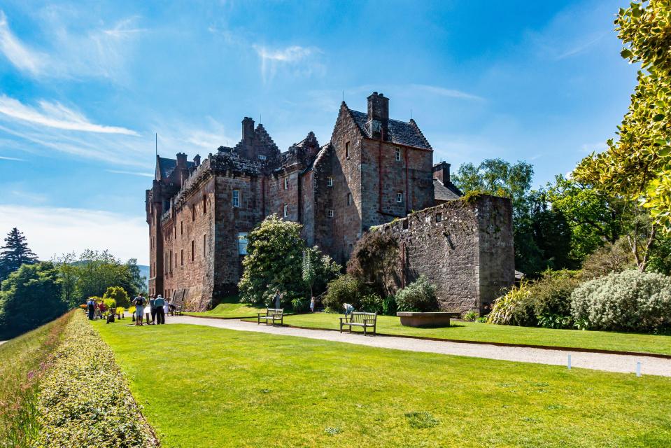 a group of people standing in front of a large castle