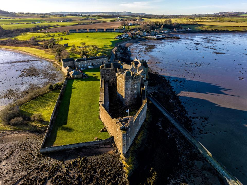 an aerial view of a castle surrounded by a body of water