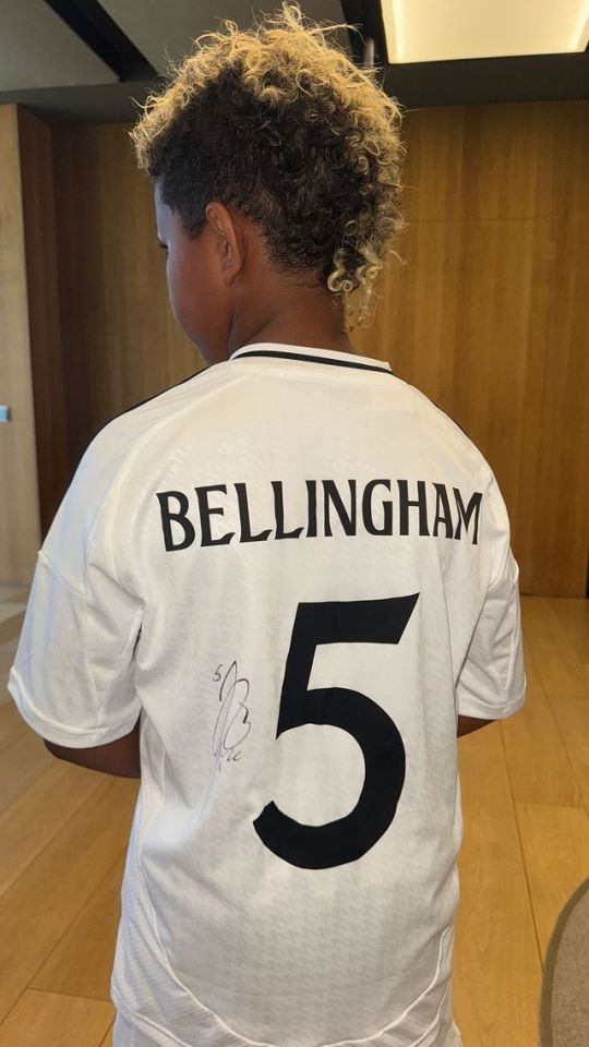 a young boy wearing a bellingham number 5 jersey