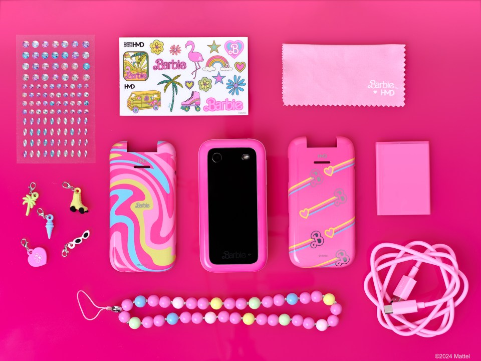 a pink barbie flip phone surrounded by accessories