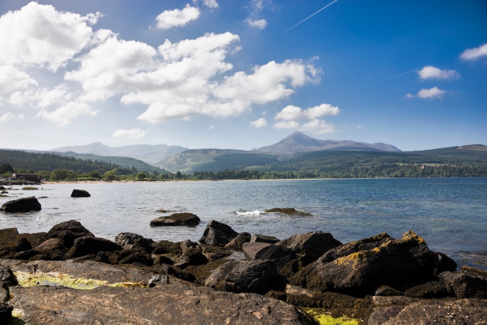 a large body of water with mountains in the background