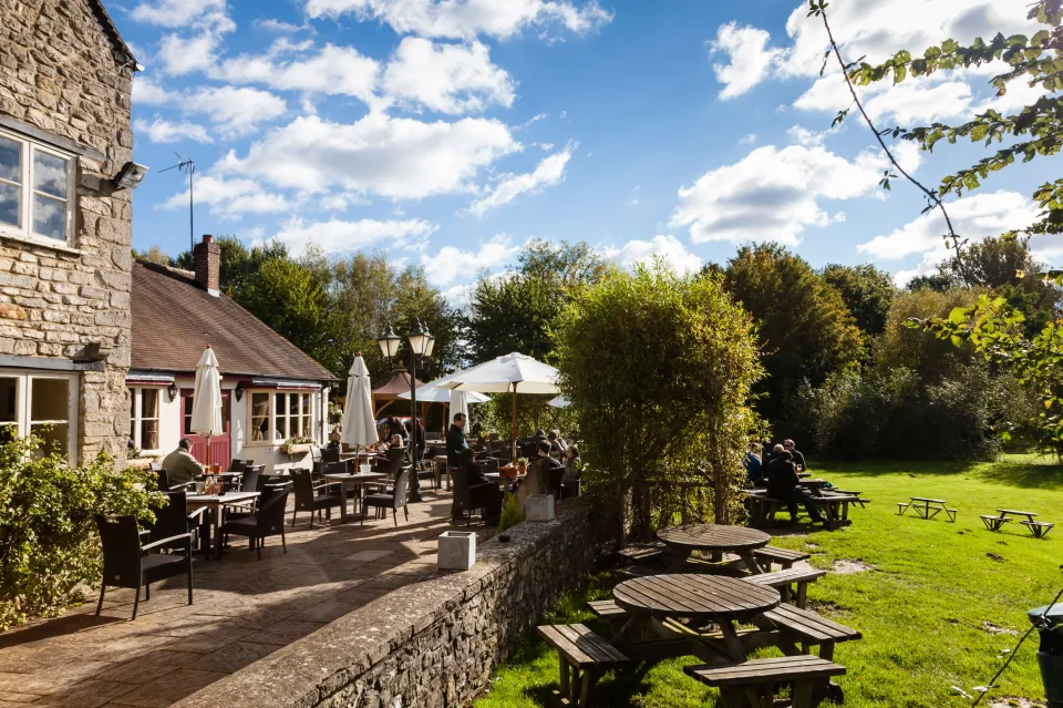 a restaurant with tables and chairs outside on a sunny day
