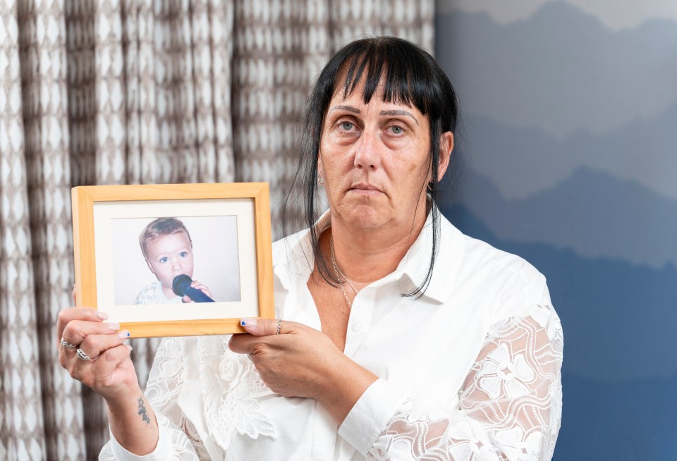 a woman is holding a picture of a baby with a microphone in his mouth