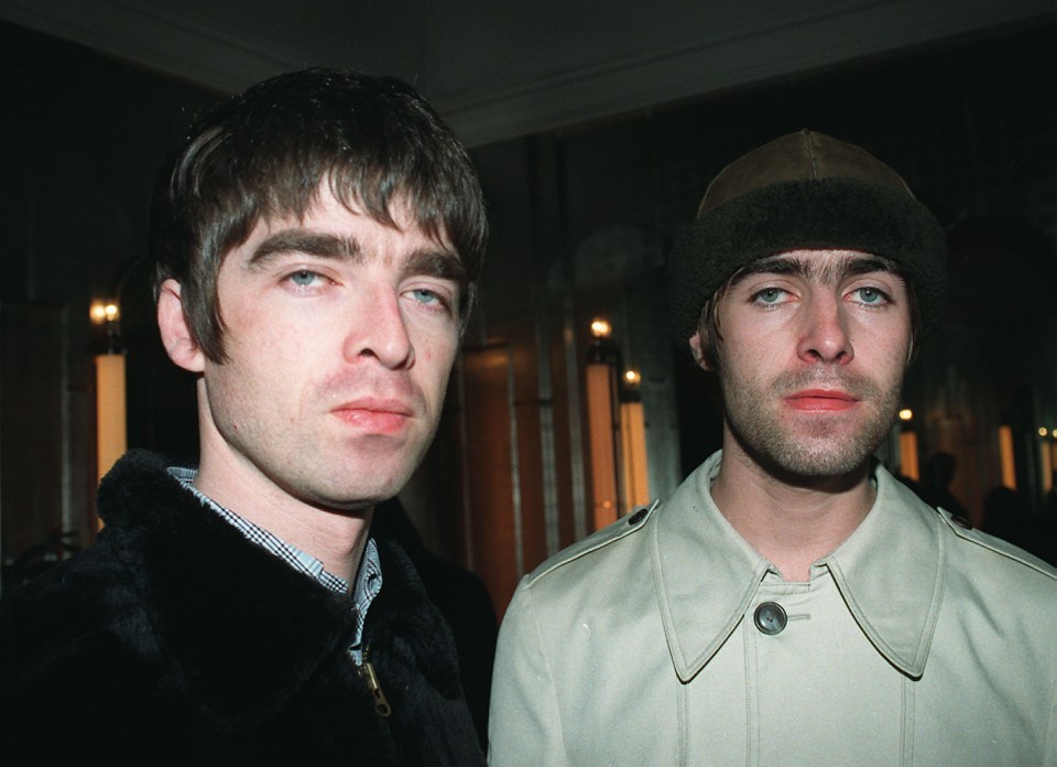 two men standing next to each other with one wearing a beanie