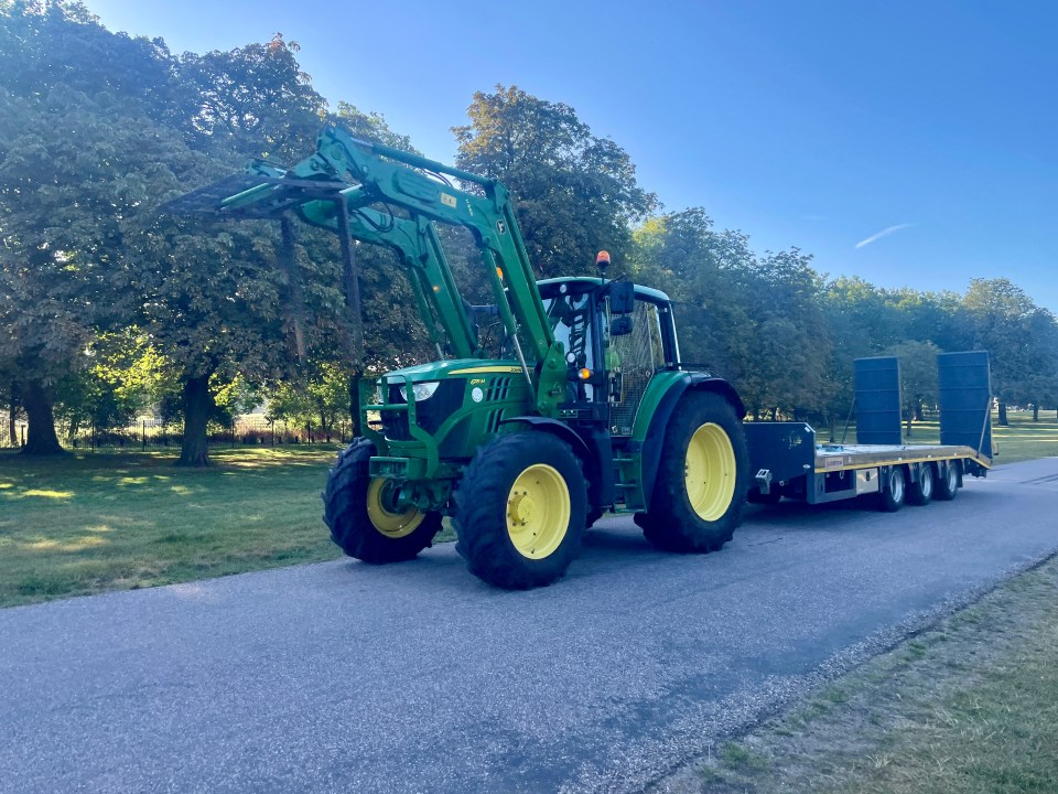 a green john deere tractor is driving down a road