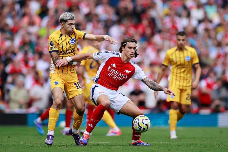 soccer player wearing a red jersey that says emirates fly better