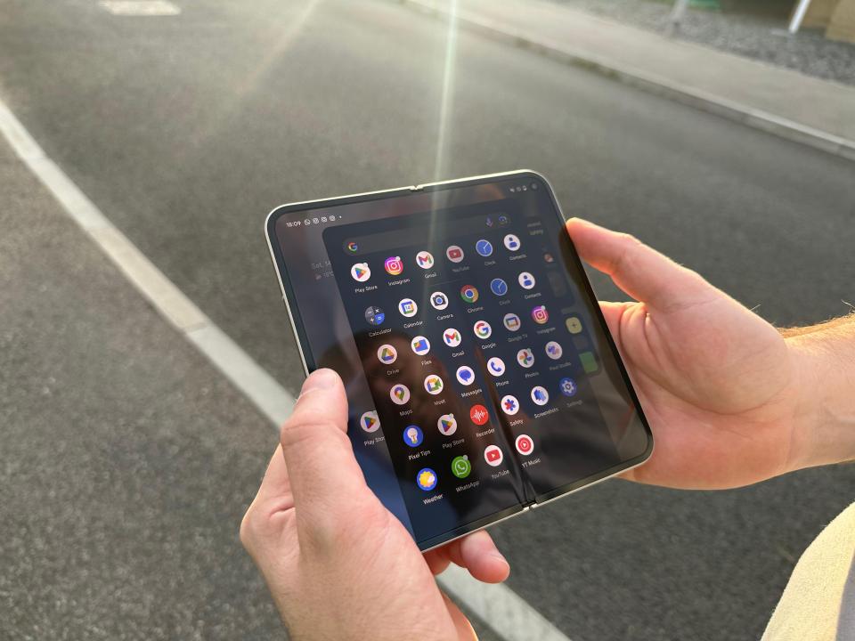 a person is holding a tablet with a bunch of apps on it
