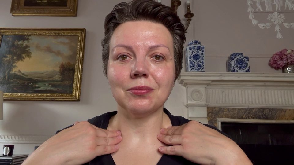 a woman 's neck is being massaged in front of a fireplace