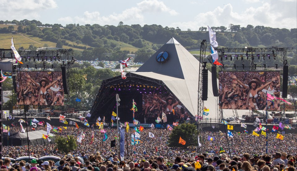 a large crowd of people are gathered at a music festival