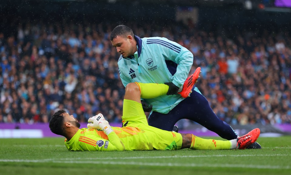 a soccer player is laying on the field with an adidas jacket on