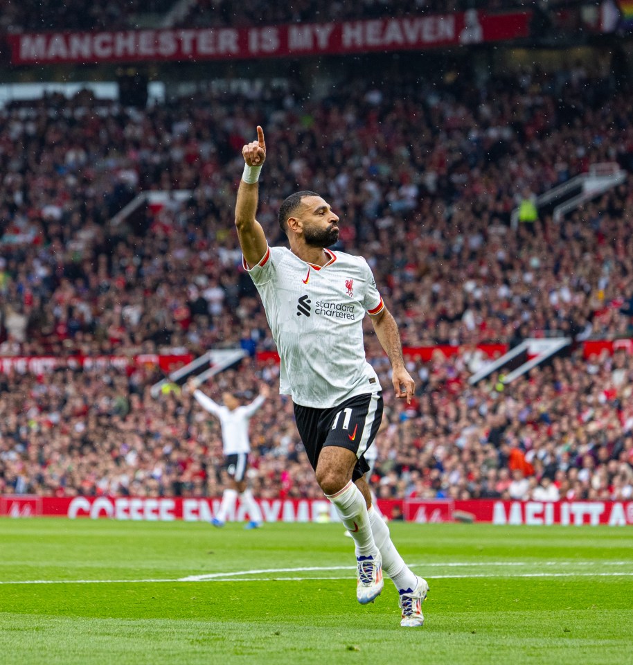 a soccer player celebrates a goal in front of a banner that says manchester is my heaven