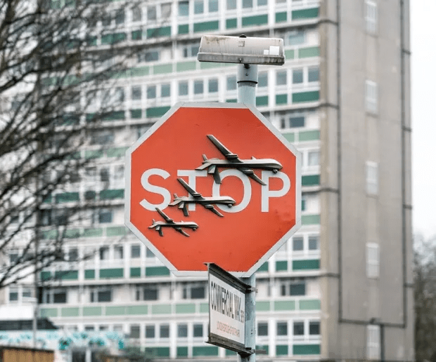 a stop sign with airplanes on it in front of a building