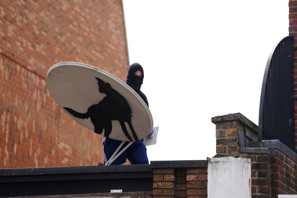 a person holding a satellite dish with a cat on it